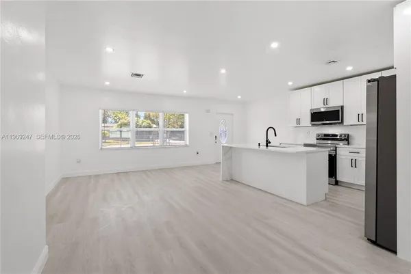 a view of a kitchen with microwave and cabinets