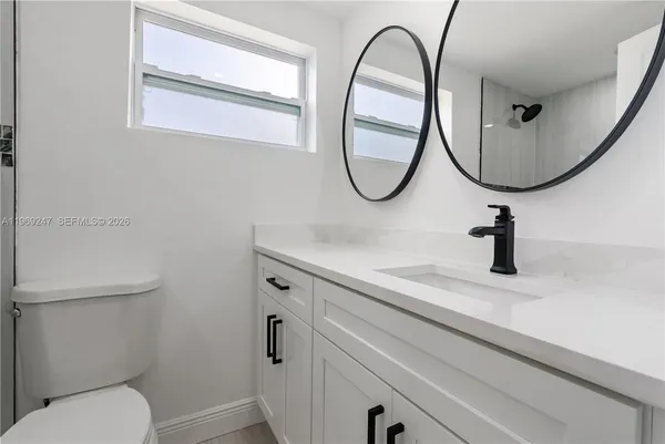 a bathroom with a toilet a sink and a mirror