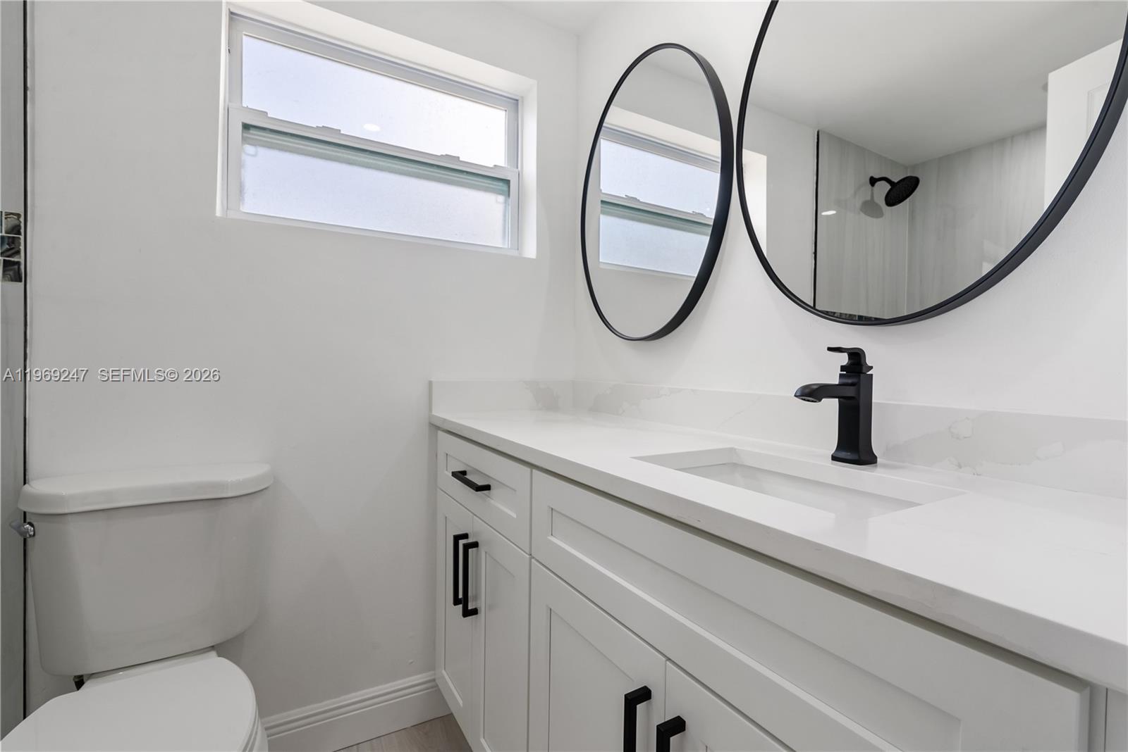 3341 Northwest 7th Street Lauderhill, FL 33311 - Photo 8 of 21 a bathroom with a toilet a sink and a mirror