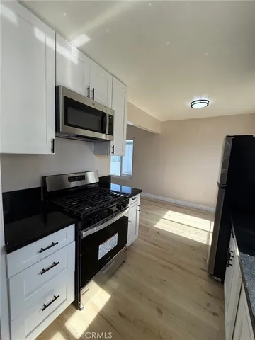 a kitchen with stainless steel appliances a stove microwave and sink