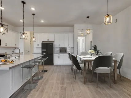 a kitchen with stainless steel appliances kitchen island granite countertop a sink a stove a dining table and chairs