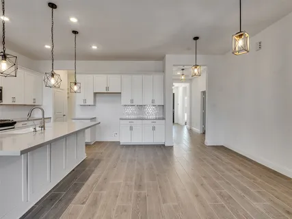 a kitchen with granite countertop white cabinets and stainless steel appliances