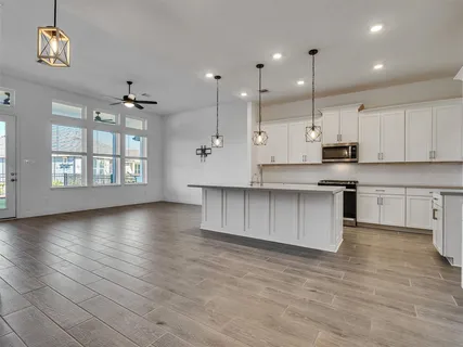 a large kitchen with cabinets wooden floor and stainless steel appliances