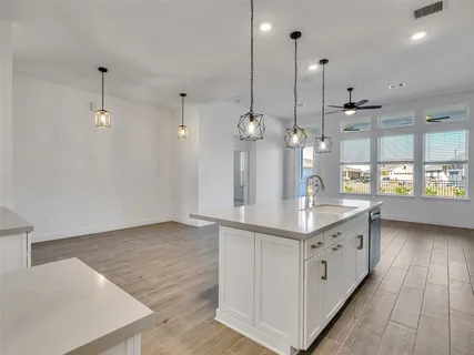a kitchen with kitchen island a counter top space and wooden floor