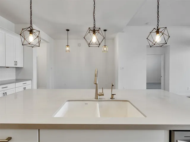 a view of a kitchen with a sink and dishwasher with wooden floor