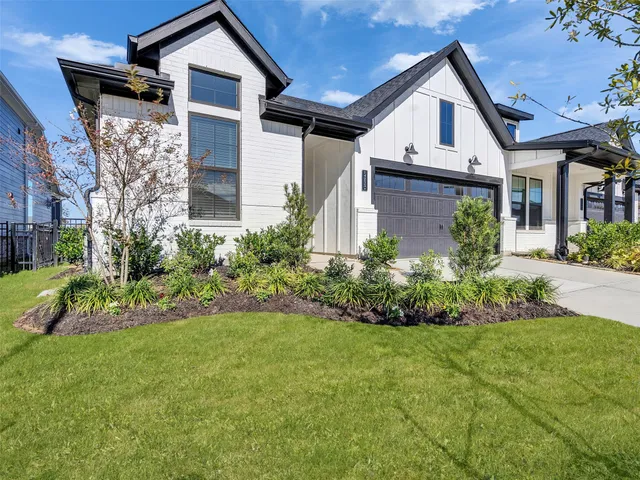 a front view of a house with a garden and plants