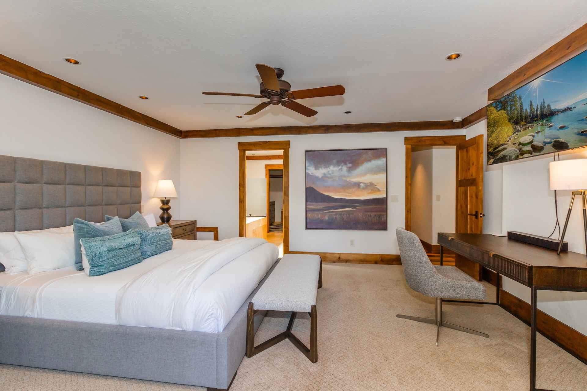 a bedroom with a bed a table and painting on the wall