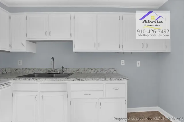a kitchen with granite countertop white cabinets and a sink