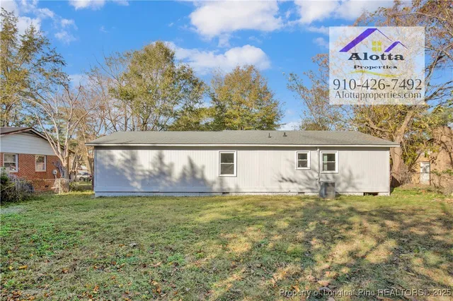 a big white house with a big yard and large trees