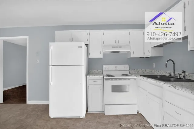 a white refrigerator freezer sitting inside of a kitchen with stainless steel appliances granite countertop white refrigerator stove and white cabinets