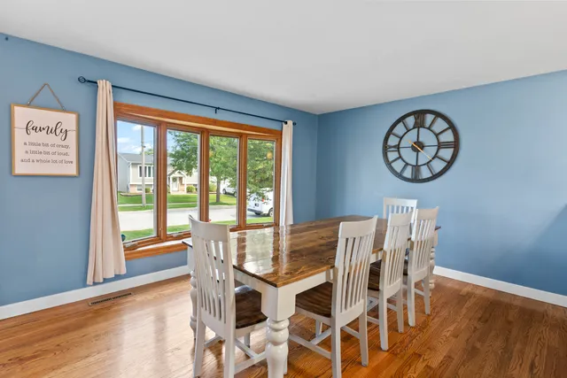 a view of a dining room with furniture a chandelier and wooden floor