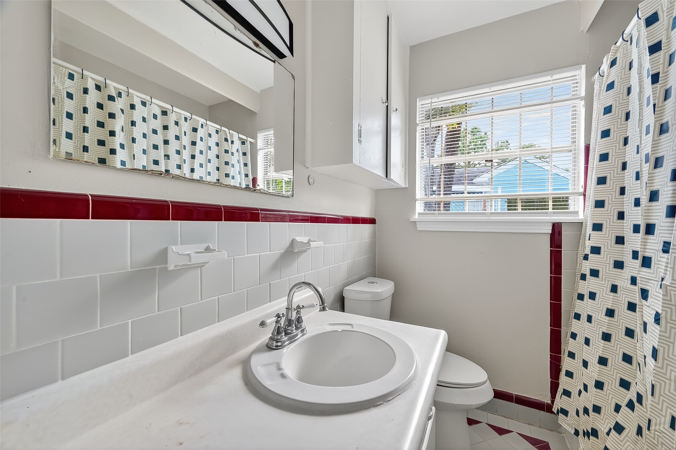 6112 Pineway Boulevard Houston, TX 77023 - Photo 18 of 21 a bathroom with a sink a toilet and a shower curtain