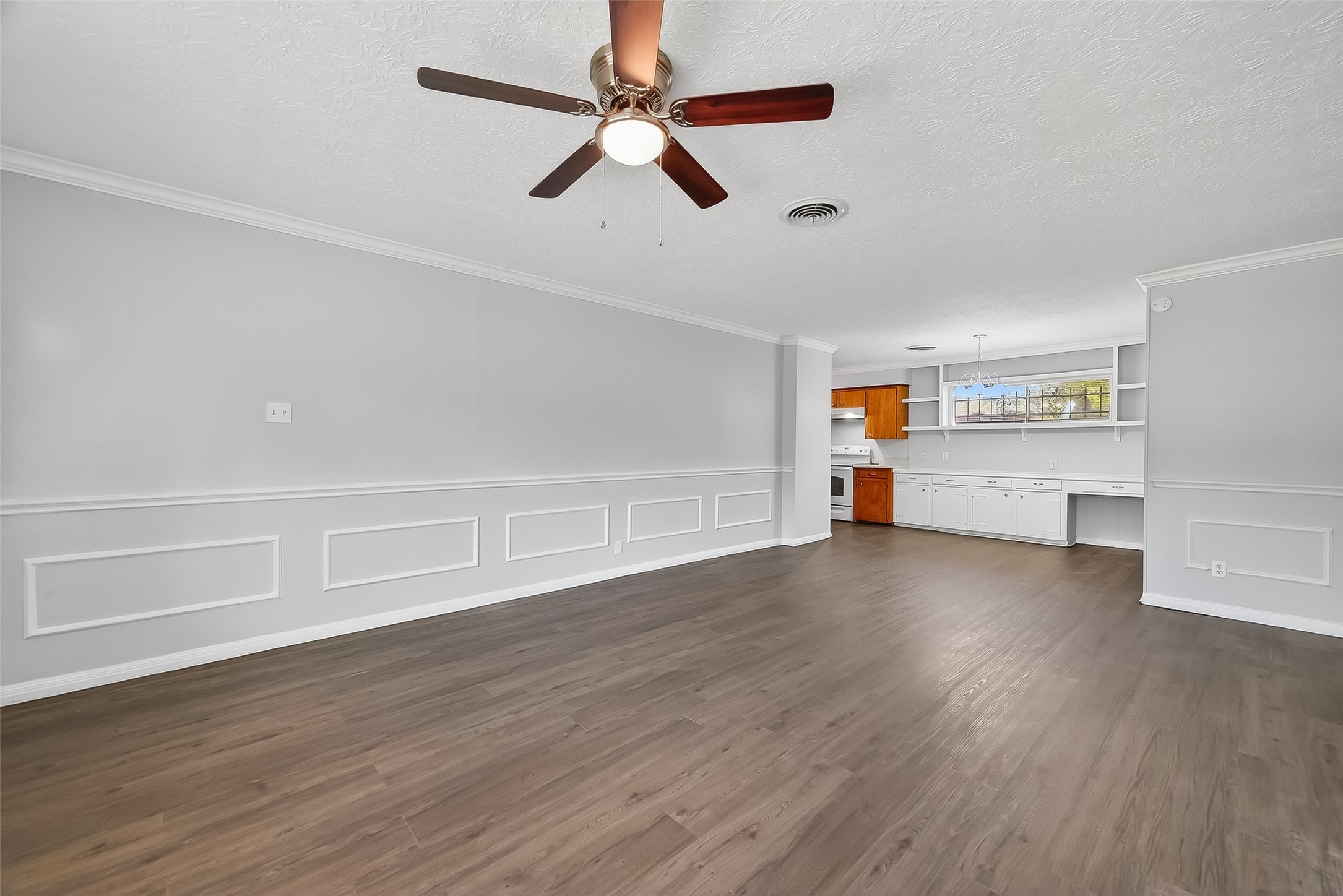 6112 Pineway Boulevard Houston, TX 77023 - Photo 5 of 21 an empty room with wooden floor ceiling fan and windows