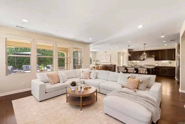 a kitchen with stainless steel appliances granite countertop a table chairs sink and cabinets