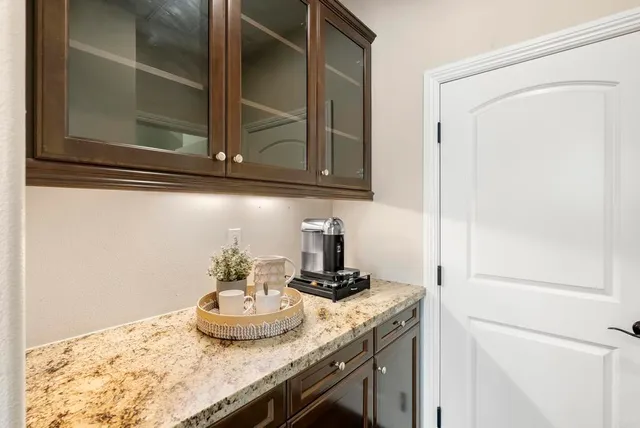 a dining hall with stainless steel appliances kitchen island granite countertop a dining table chairs and view living room