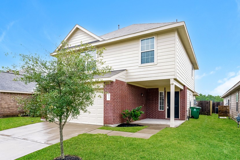 a front view of a house with a garden and yard