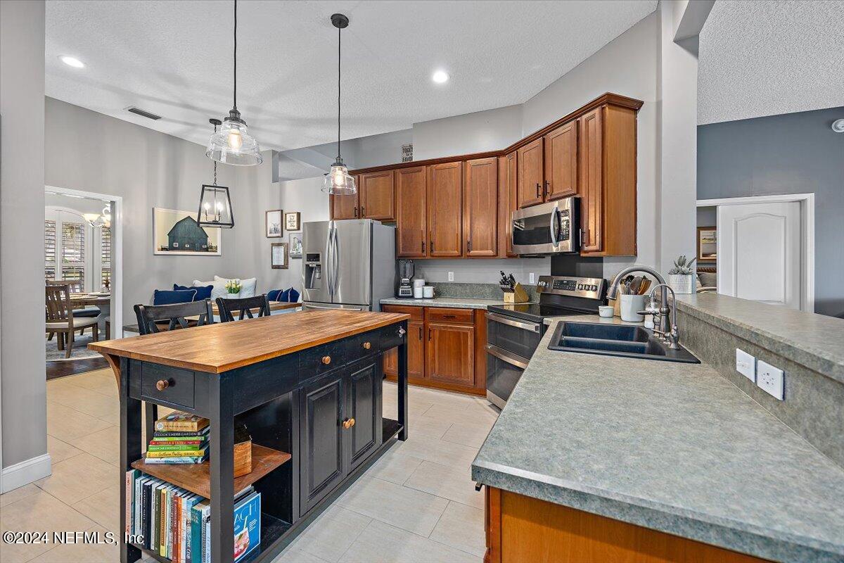 11322 Mandarin Ridge Lane Jacksonville, FL 32258 - Photo 29 of 37 a kitchen with stainless steel appliances granite countertop a stove a sink a refrigerator and a microwave