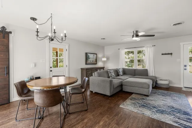 a living room with furniture a chandelier and a window