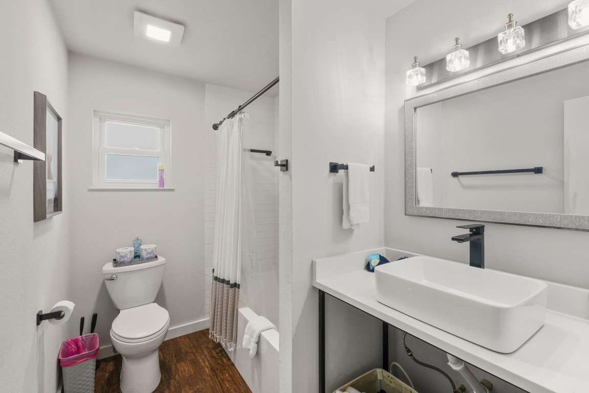 219 Bluff Street Dripping Springs, TX 78620 - Photo 14 of 40 a bathroom with a sink toilet and a mirror