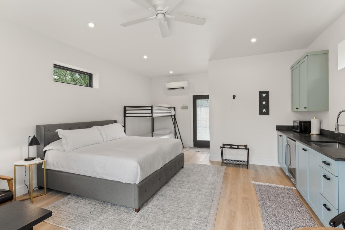 219 Bluff Street Dripping Springs, TX 78620 - Photo 25 of 40 a bedroom with a large bed and a chandelier