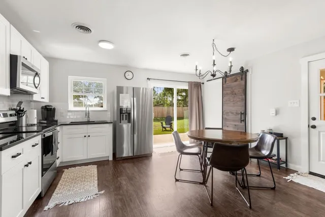 a view of a dining room with furniture and chandelier