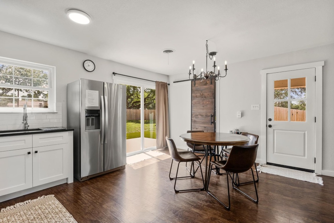 219 Bluff Street Dripping Springs, TX 78620 - Photo 10 of 40 a dining room with furniture a chandelier and wooden floor