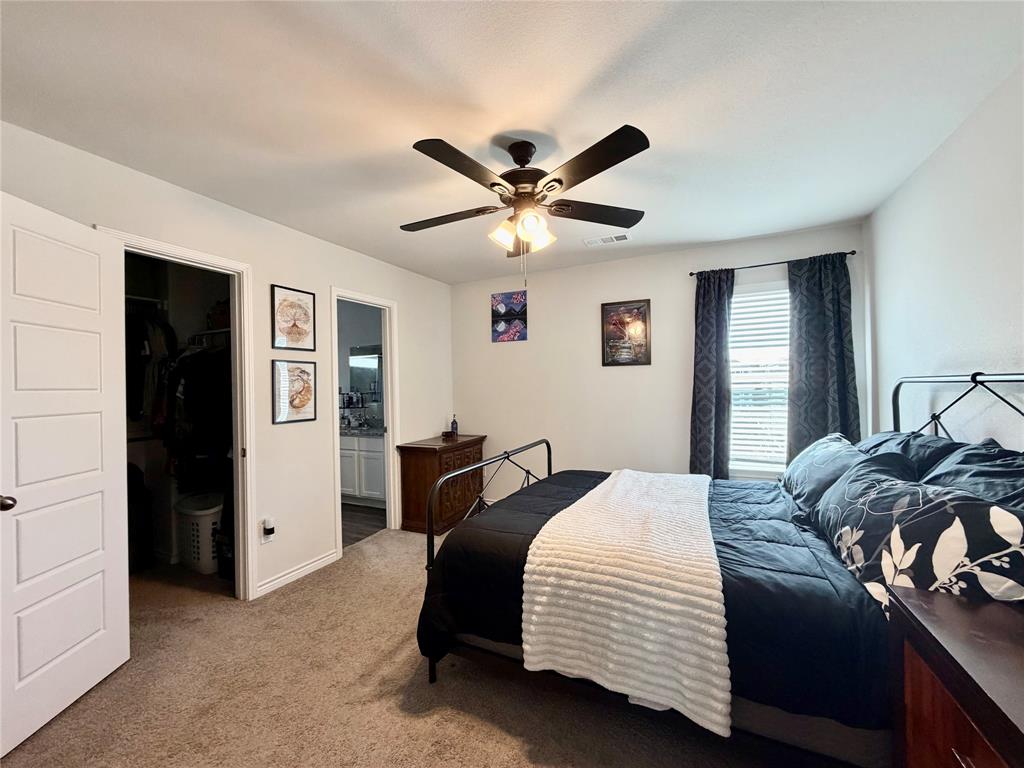 5664 Shore Point Trail Fort Worth, TX 76119 - Photo 13 of 29 a bedroom with a bed and a chandelier