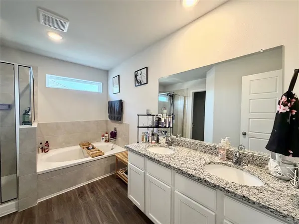 a bathroom with a granite countertop tub sink and mirror