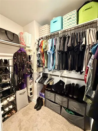 a view of walk in closet with clothes and shoes