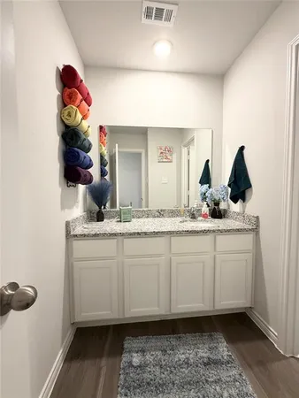 a bathroom with a granite countertop sink and a mirror