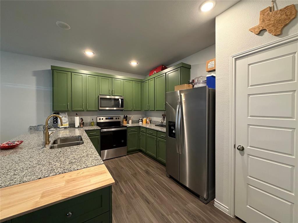 5664 Shore Point Trail Fort Worth, TX 76119 - Photo 7 of 29 a kitchen with a refrigerator and a sink