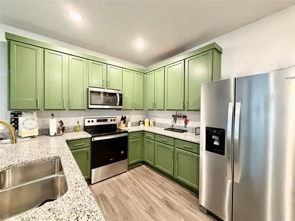 a kitchen with stainless steel appliances granite countertop a refrigerator and a sink