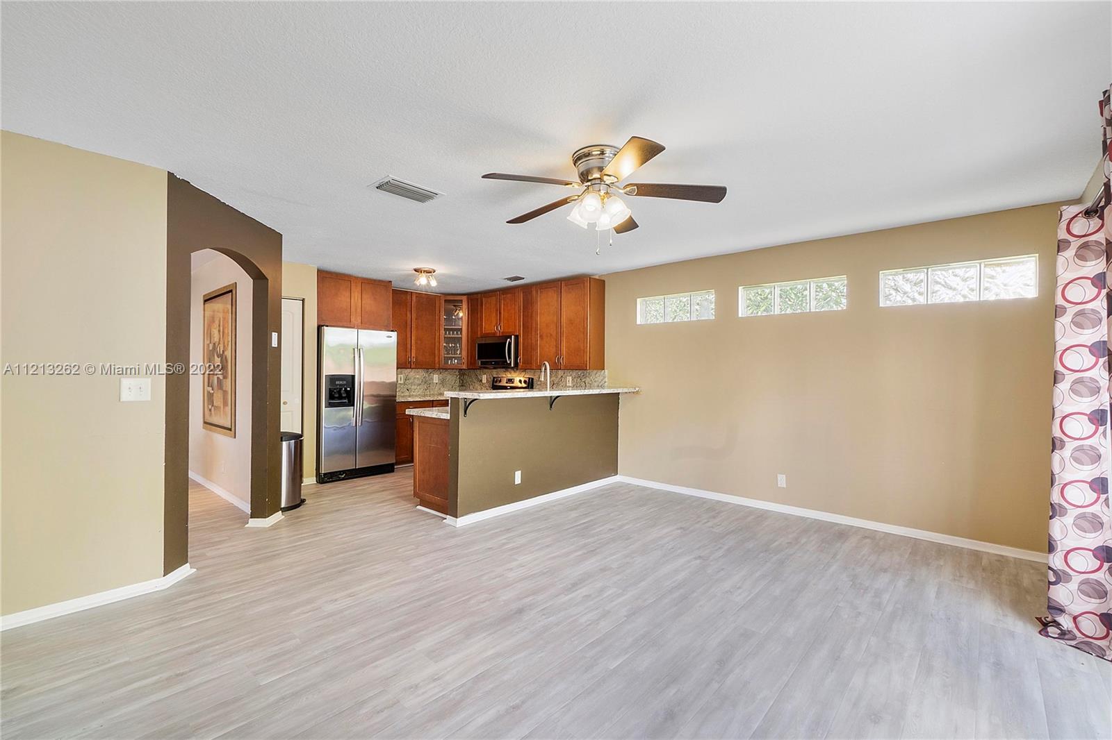 3123 Sunset Circle Margate, FL 33063 - Photo 11 of 58 a view of a kitchen with a refrigerator a microwave and a ceiling fan