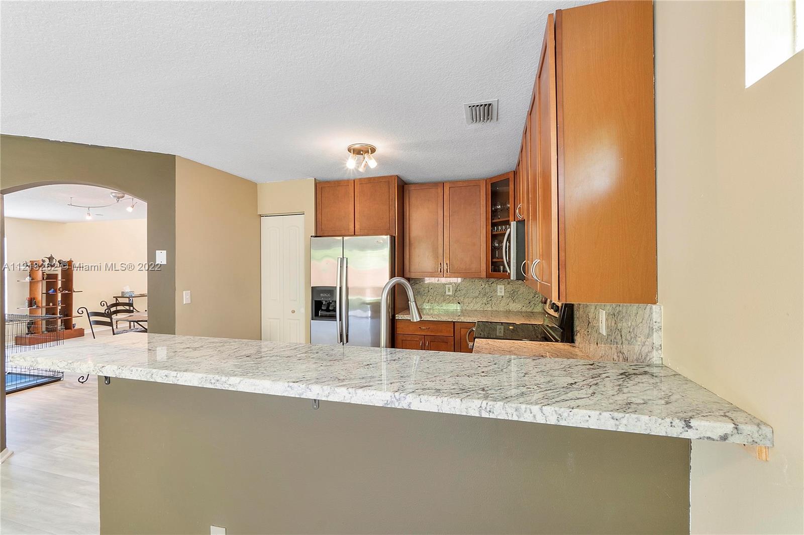 3123 Sunset Circle Margate, FL 33063 - Photo 16 of 58 a kitchen with stainless steel appliances granite countertop a sink and a refrigerator