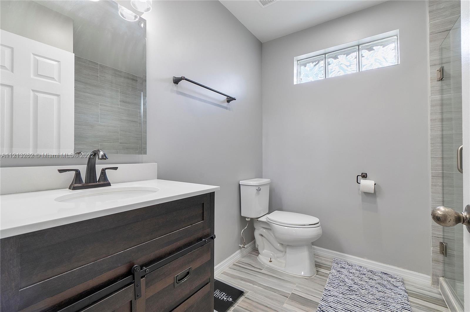 3123 Sunset Circle Margate, FL 33063 - Photo 21 of 58 a bathroom with a sink a toilet a window and vanity