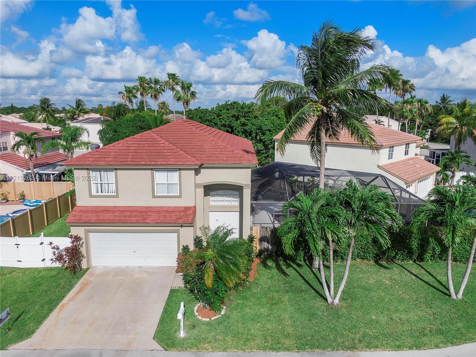 3123 Sunset Circle Margate, FL 33063 - Photo 3 of 58 a front view of a house with a yard and potted plants
