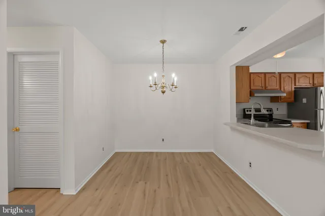 a view of a room with wooden floor and a ceiling fan