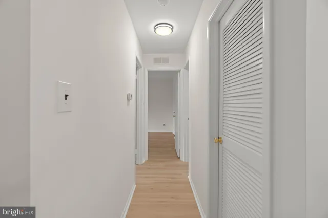 a view of a hallway with wooden floor