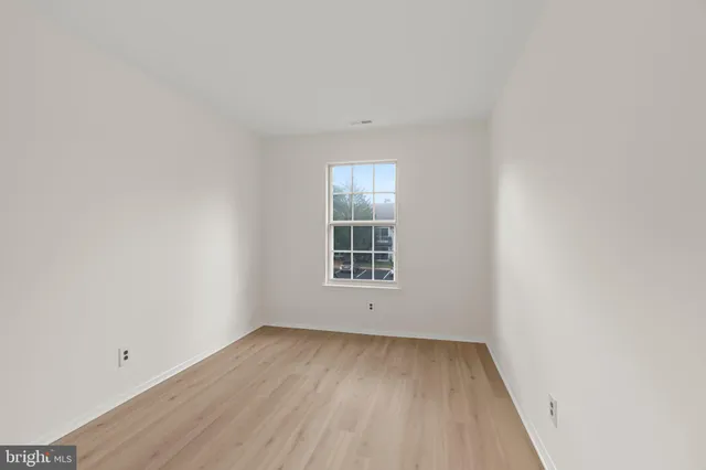 a view of a room that has wooden floor and window