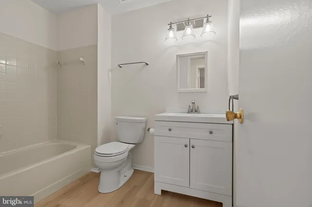 a bathroom with a sink toilet vanity and tub