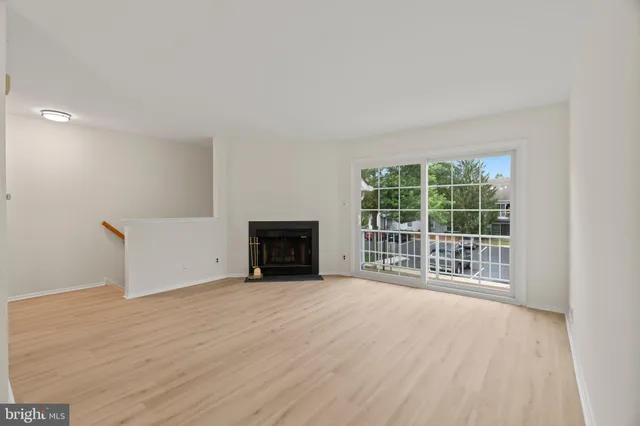 a view of an empty room with a fireplace and a window
