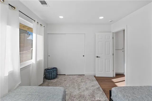a bedroom with a bed and wooden floor