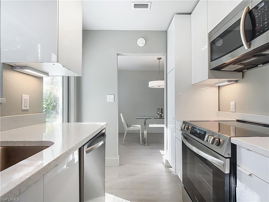 2544 First Street, Unit 102 Fort Myers, FL 33901 - Photo 15 of 26 a kitchen with stainless steel appliances granite countertop a sink a stove and a refrigerator