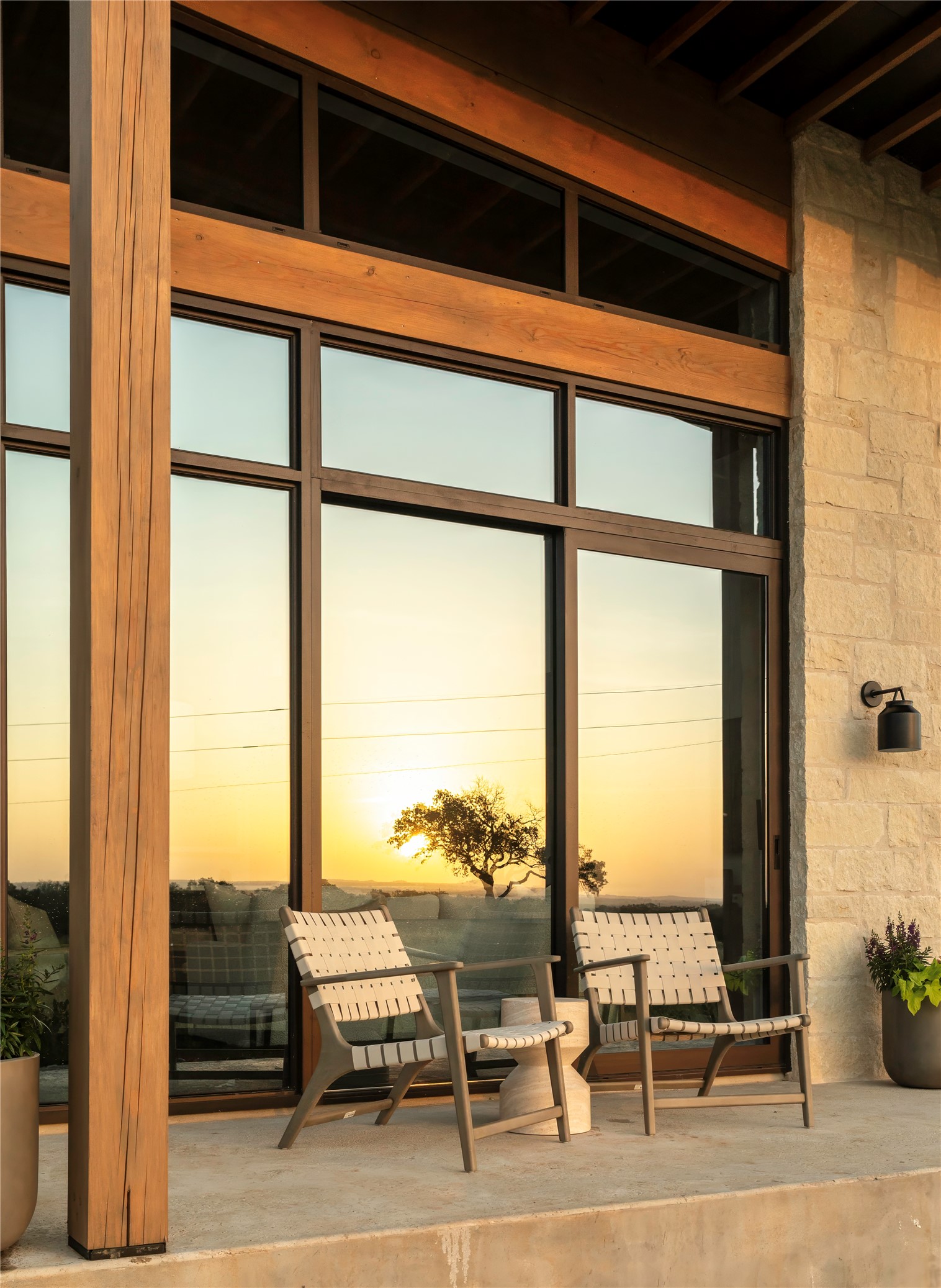 312 Hye Springs Road, Unit 106 Hye, TX 78635 - Photo 17 of 17 A striking facade combines wood and stone with generous windows, framing a picturesque sunset.