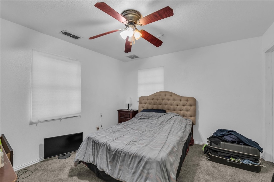 1940 East Highland Road Waxahachie, TX 75167 - Photo 32 of 44 a bedroom with a bed and a chandelier