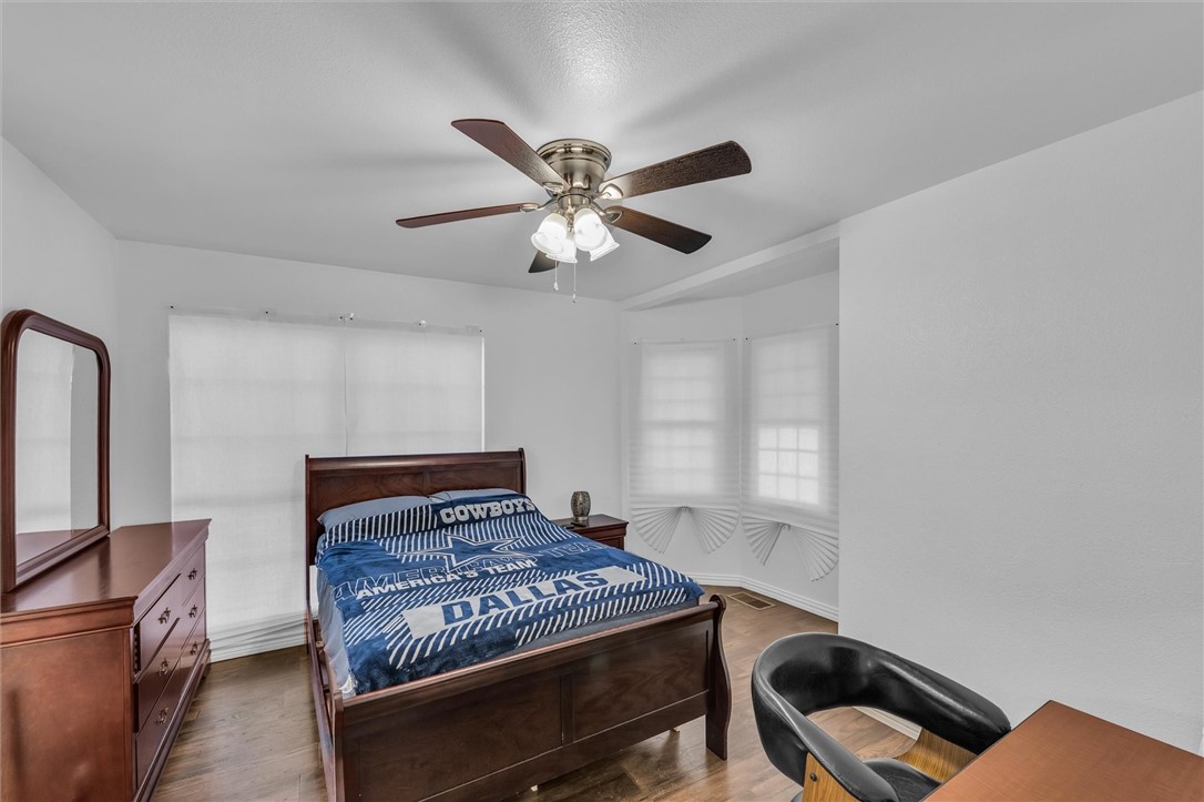 1940 East Highland Road Waxahachie, TX 75167 - Photo 40 of 44 a bedroom with a bed and a chandelier