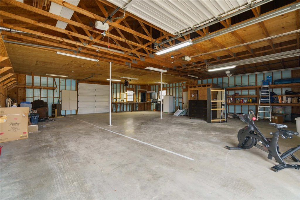 5014 Little Valley Road Leander, TX 78641 - Photo 3 of 20 A spacious, well-lit garage with exposed wooden beams offers ample storage and workspace.
