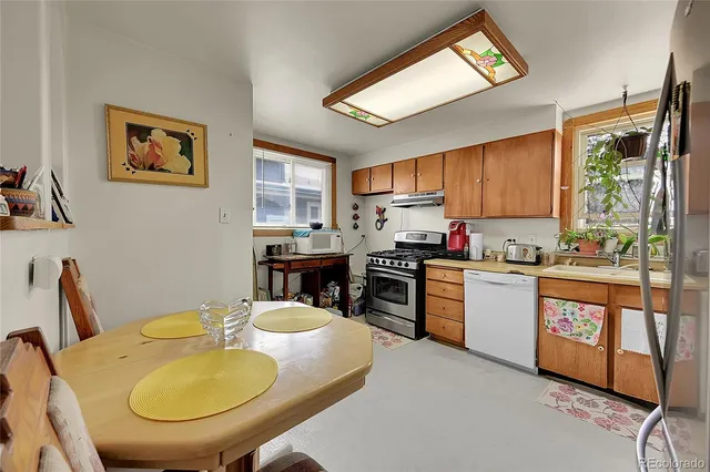 a kitchen with stainless steel appliances granite countertop a stove a sink a microwave a dining table and chairs