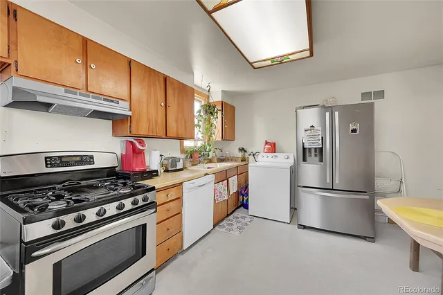 a kitchen with stainless steel appliances granite countertop a stove a refrigerator and a refrigerator