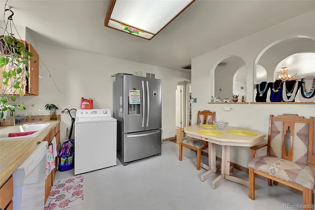a living room with furniture and a dining table with kitchen